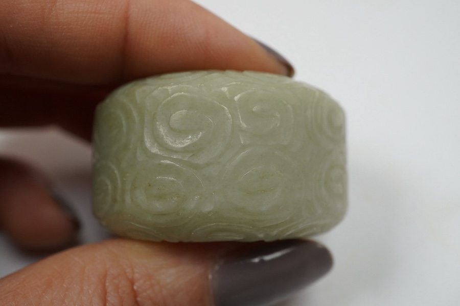 A Chinese celadon jade 'cloud' thumb ring, 4cm diameter. Condition - good